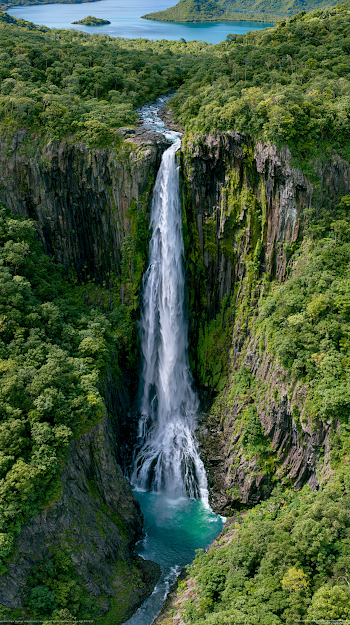 Aerial View of a Majestic Waterfall Cascading into a Turquoise Pool