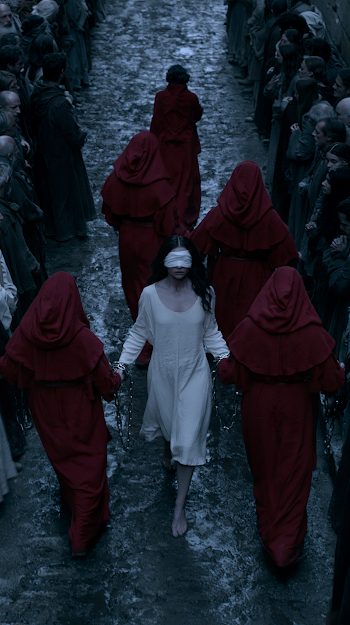 Blindfolded Woman in White Dress Led Through Medieval Street