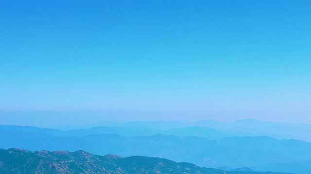 Serene Layered Mountain Landscape Under Clear Blue Sky