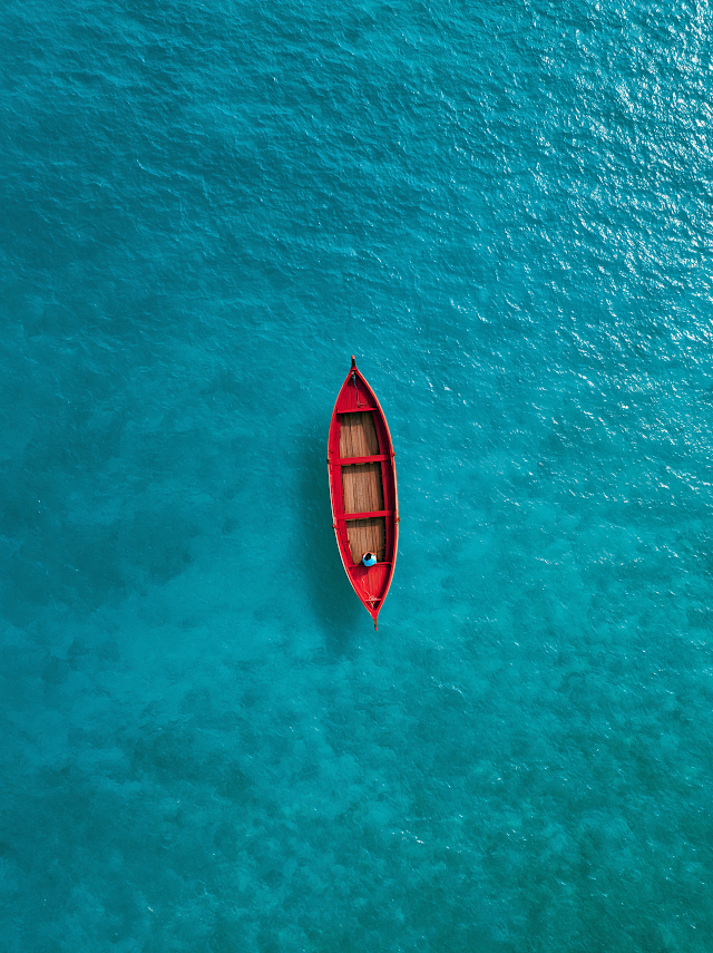 Serenity on Crystal Waters with a Red Boat