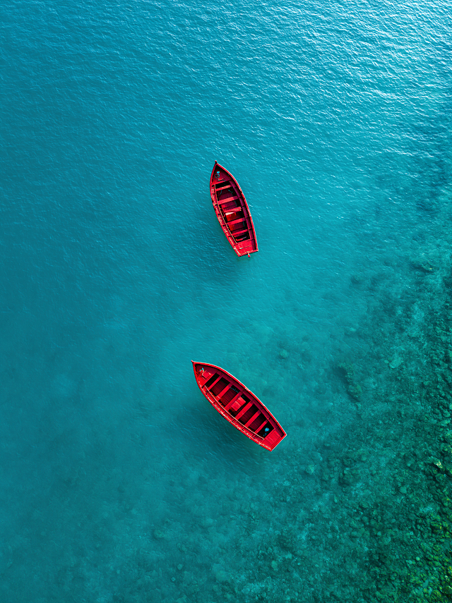 Tranquil Aerial View of Red Boats on Crystal Clear Water