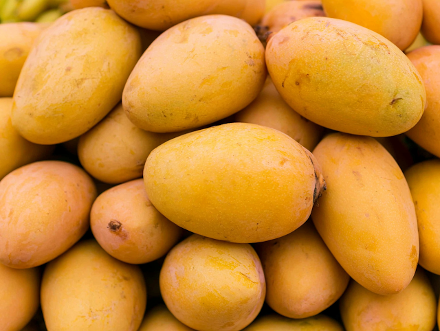 Vibrant Pile of Ripe Yellow Mangoes at Market Stall